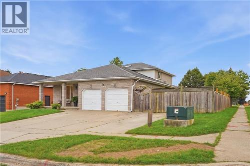 Stone facade, two-car garage, covered entry, mature privacy fence, paved driveway - 76 Madeira Crescent, Cambridge, ON 
