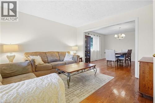 Hardwood flooring throughout, neutral paint palette, and a cased opening to the dining area - 76 Madeira Crescent, Cambridge, ON 