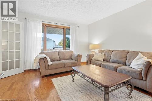 Wood-finish flooring with a large area rug - 76 Madeira Crescent, Cambridge, ON 
