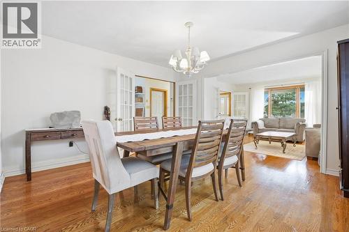 Hardwood flooring throughout, white walls, and a chandelier lighting fixture - 76 Madeira Crescent, Cambridge, ON 