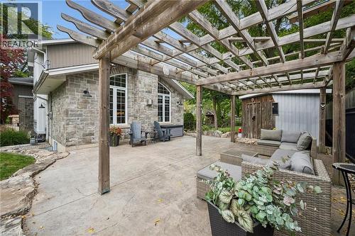 Expansive concrete patio with a large wooden pergola - 112 Margaret Avenue N, Waterloo, ON 