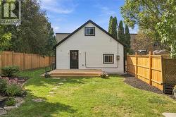 Expansive backyard featuring a new wooden deck, privacy fencing, natural stone path, landscaped garden beds, and clear sightlines to the property - 