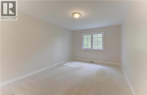 Recessed window with white trim, light-toned carpeting, and a flush-mount ceiling light fixture (NEW CARPET) - 25 Bankside Drive Unit# 2, Kitchener, ON 