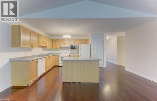 Kitchen featuring wood-finish cabinetry, light-toned countertops, and a central island - 25 Bankside Drive Unit# 2, Kitchener, ON 