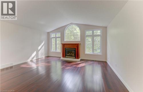 Vaulted ceiling accenting a prominent fireplace with a wood mantel - 25 Bankside Drive Unit# 2, Kitchener, ON 