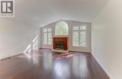 Vaulted ceiling accenting a prominent fireplace with a wood mantel - 