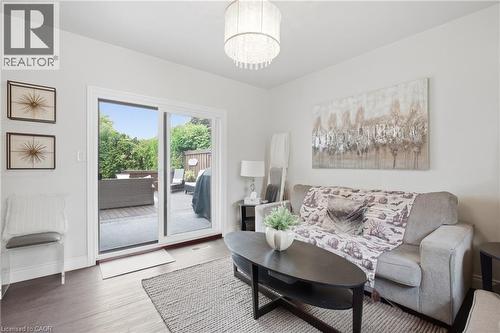 Wood-finish flooring, sliding glass patio doors, and a decorative ceiling fixture - 22 Sycamore Street, Hamilton, ON 