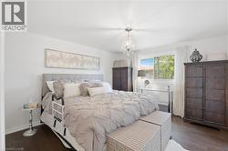 Hardwood-style flooring throughout, complemented by a large window with white trim - 