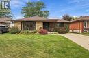 Brick and stone facade, front yard with mature landscaping, pitched shingle roof, paved driveway, and covered entry - 22 Sycamore Street, Hamilton, ON 