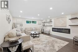 Recessed lighting illuminates the wood-finish flooring and integrated linear fireplace - 