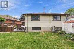 Expansive backyard featuring a wood deck, wood privacy fencing, and a manicured lawn - 