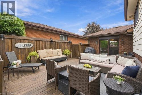 Expansive outdoor deck with a wooden privacy fence and exterior wall-mounted lighting - 22 Sycamore Street, Hamilton, ON 
