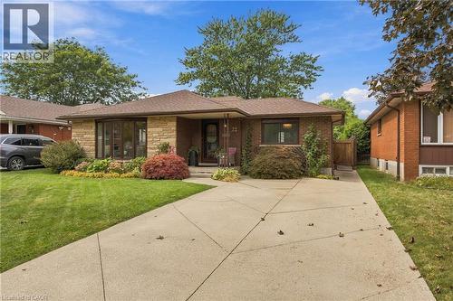 Brick and stone veneer exterior with a bay window, concrete driveway, and established front landscaping - 22 Sycamore Street, Hamilton, ON 