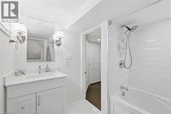 White shaker vanity with integrated sink, chrome faucet, and sconce lighting - 