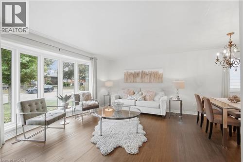 Expansive bay window, wood-finish flooring, recessed lighting, and ornate chandelier - 22 Sycamore Street, Hamilton, ON 