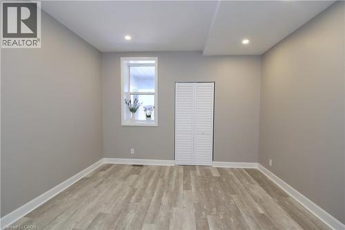 Recessed lighting, light gray wall finishes, wood-finish flooring, white window trim, and louvered bifold closet doors - 76 Burlington Street E, Hamilton, ON 