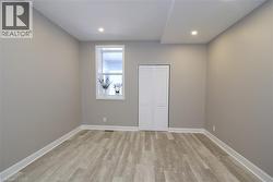 Recessed lighting, light gray wall finishes, wood-finish flooring, white window trim, and louvered bifold closet doors - 