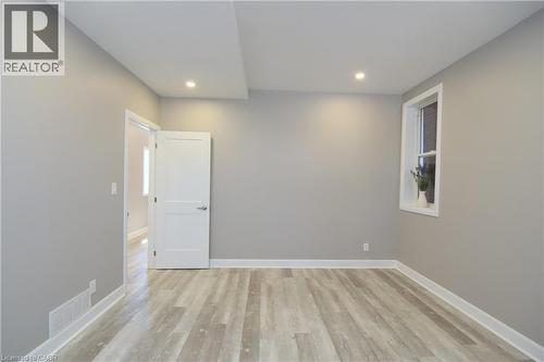 Recessed lighting, wood-finish flooring, neutral paint, white trim, and a window with white casing - 76 Burlington Street E, Hamilton, ON 