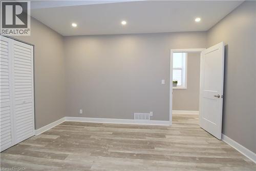 Recessed lighting, wood-finish flooring, white baseboards, and louvered bifold closet doors - 76 Burlington Street E, Hamilton, ON 