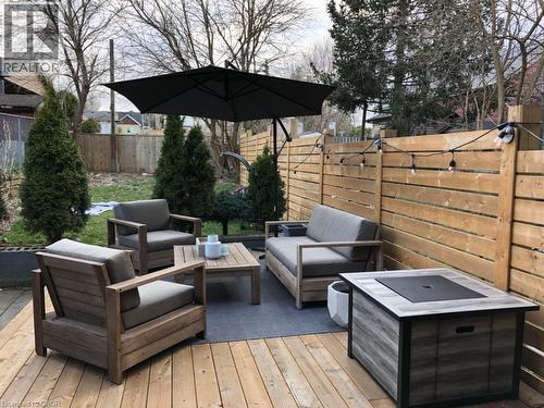 Hardwood deck with a privacy fence, string lighting, and mature landscaping - 76 Burlington Street E, Hamilton, ON 