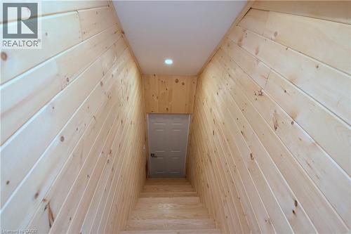 Wood-paneled walls with natural wood grain, recessed ceiling lighting, wood stairs, and a paneled door - 76 Burlington Street E, Hamilton, ON 