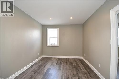 Recessed ceiling lighting, wood-finish flooring, neutral wall paint, white trim, and a single window - 76 Burlington Street E, Hamilton, ON 