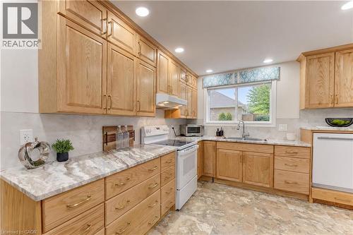 Kitchen featuring wood cabinetry, light-toned countertops, a tile backsplash, and recessed lighting - 422 Grangewood Drive, Waterloo, ON 