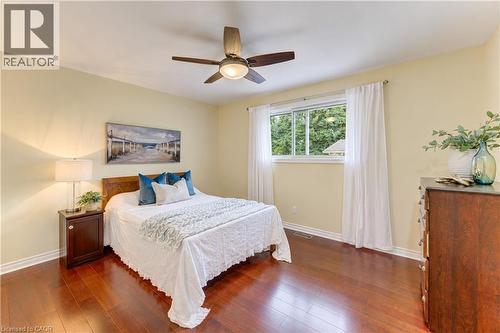 Hardwood flooring, ceiling fan with integrated lighting, neutral wall color, and a window with white trim - 422 Grangewood Drive, Waterloo, ON 