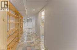 Built-in wood shelving, tiled flooring, recessed lighting, and a white drop ceiling - 