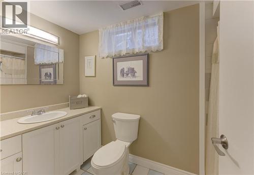 Bathroom featuring a vanity with an integrated sink, white cabinetry, and a full wall mirror - 422 Grangewood Drive, Waterloo, ON 