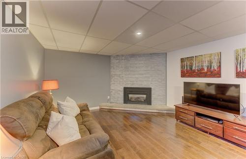 Hardwood-style flooring, a built-in fireplace with a stone surround, recessed lighting, and a drop ceiling - 422 Grangewood Drive, Waterloo, ON 