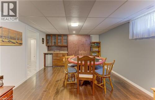 Wood-finish flooring throughout, recessed lighting, and a built-in wet bar with cabinetry and a compact refrigerator - 422 Grangewood Drive, Waterloo, ON 