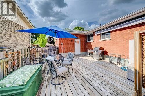 Expansive wood deck with a privacy fence, exterior brick siding, and direct access door - 422 Grangewood Drive, Waterloo, ON 