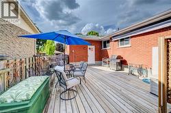 Expansive wood deck with a privacy fence, exterior brick siding, and direct access door - 