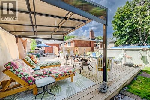 Patio featuring a metal-framed pergola with a translucent roof, a wooden deck, and a grass area - 422 Grangewood Drive, Waterloo, ON 