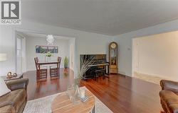 Rich wood-finish flooring extends through the main living areas, complemented by white walls and trim - 