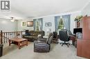 Carpeted living area with a built-in office desk, multiple windows, and a ceiling fan with integrated lighting - 1311 W Concession 6 Road, Flamborough, ON 