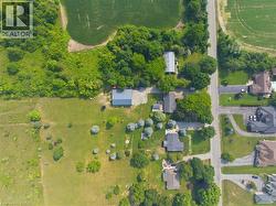 Expansive property featuring a large green space, mature trees, and an additional outbuilding with a gray metal roof - 