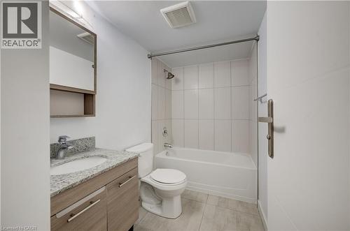 Light-toned wood-finish vanity with a mounted sink and stone countertop - 338 Albert Street Unit# 114, Waterloo, ON 