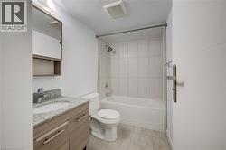 Light-toned wood-finish vanity with a mounted sink and stone countertop - 