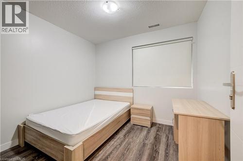 Wood-finish flooring, white walls, flush mount lighting, and a window with a roller shade - 338 Albert Street Unit# 114, Waterloo, ON 