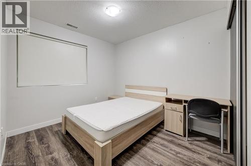 Wood-finish flooring, white walls, and a window with a roller shade - 338 Albert Street Unit# 114, Waterloo, ON 