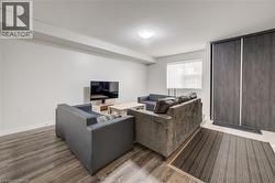 Wood-finish flooring throughout, bright white walls, and a window with roller shade - 