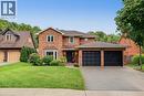 Brick exterior with a gabled roofline, bay window, and a two-car attached garage - 141 Race Street, Paris, ON 