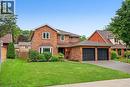 Brick two-story exterior with a bay window, asphalt shingle roof, and an attached two-car garage - 141 Race Street, Paris, ON 