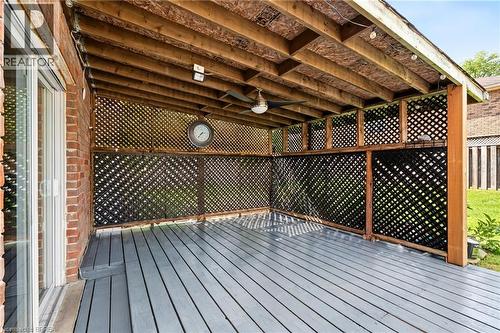 Covered outdoor deck with painted wood flooring, exposed wood beam ceiling, and lattice privacy screens - 141 Race Street, Paris, ON 