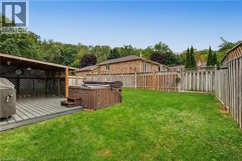 Expansive backyard featuring a covered patio, a built-in hot tub, and a manicured lawn - 141 Race Street, Paris, ON 