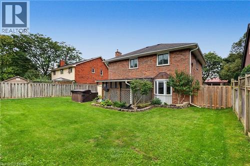Brick exterior with a bay window, sheltered patio area, and a wood privacy fence - 141 Race Street, Paris, ON 