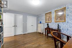 Main floor bedroom with hardwood floor and closets - 