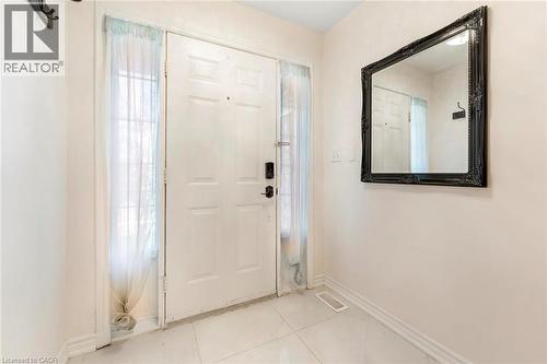 White paneled entry door with sidelights, complemented by white tile flooring - 123 Brickyard Way, Brampton, ON 